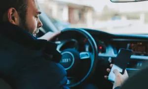 мужчина смотрит в телефон в машине